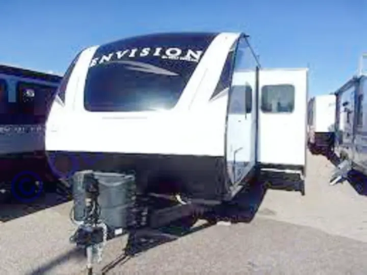 A sleek black and white Envision travel trailer, available for RV rental, with an open side door on a sunny lot.. Gulf Stream Envision 2021