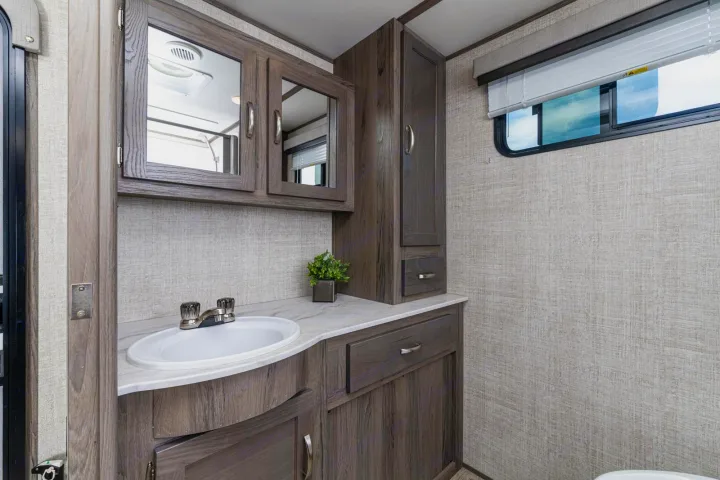 Modern RV rental bathroom with vanity, sink, and ample storage.. Gulf Stream Envision 2021