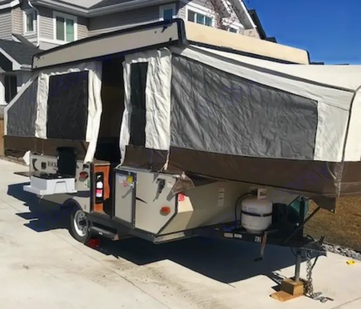 RV rental: This pop-up camper is set up, featuring an outdoor kitchen and propane tank, ready for adventure.. Forest River 1940 LTD 2018