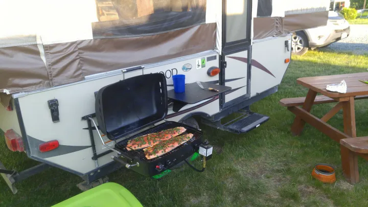 RV rental camping: Fresh salmon grilling on an attached BBQ, perfect for an outdoor cooking experience at the campsite.. Forest River 1940 LTD 2018