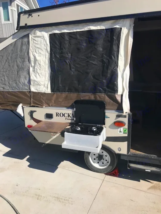 Pop-up camper with an outdoor kitchen setup, perfect for your next RV rental camping trip.. Forest River 1940 LTD 2018