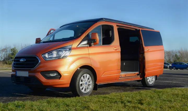 Bright orange Ford Transit Custom camper van with open doors, ideal for RV rental adventures.. Ford Custom 2018