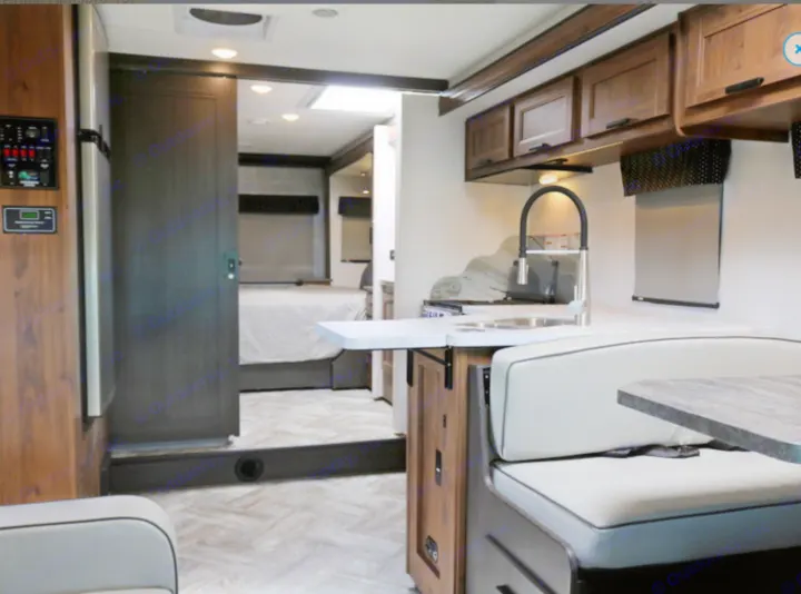 Explore this RV rental's modern interior: full kitchen, comfy dinette, and private bedroom beyond the sliding door.. Forest River Other 2021