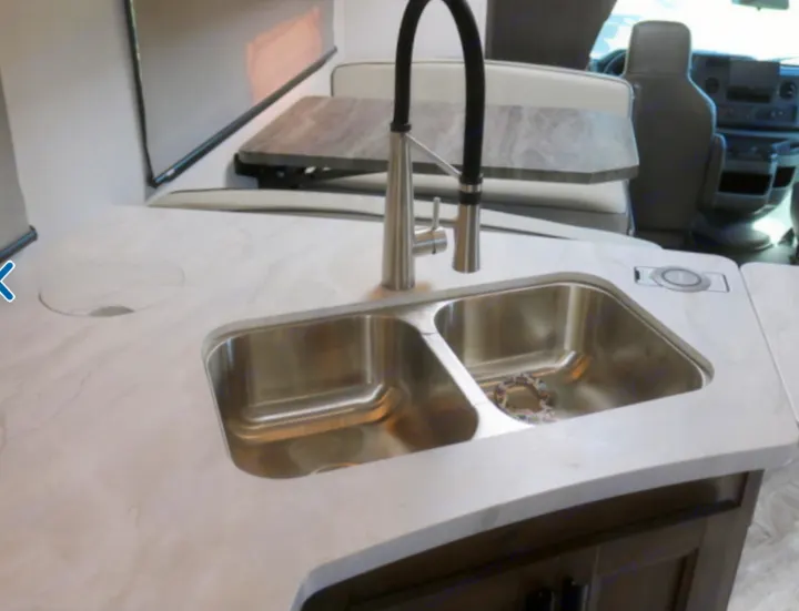RV rental kitchen: double sink, modern faucet, and light countertop with wireless charging pad. Dinette beyond.. Forest River Other 2021
