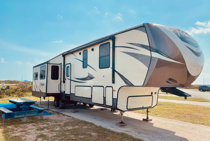 Volante fifth-wheel RV rental at a sunny campsite, ready for camping and travel adventures.. Keystone Volante 3801MD 2018