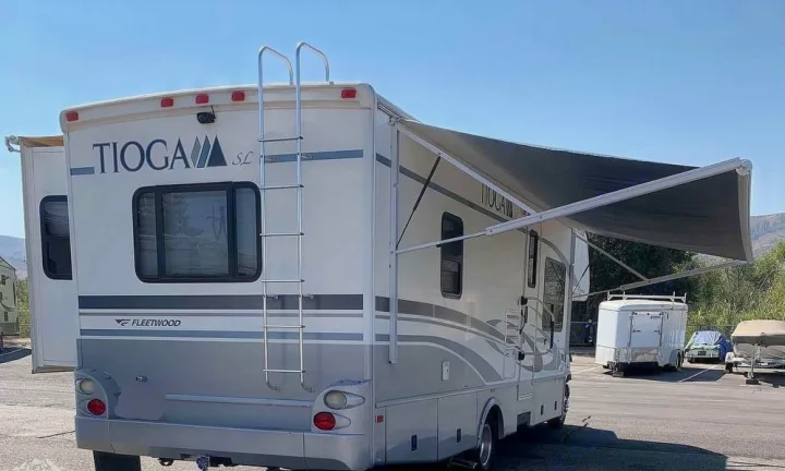 White & gray Fleetwood Tioga SL RV rental with extended awning & rear ladder, ideal for your next trip.. Tioga M-30u Ford 2005