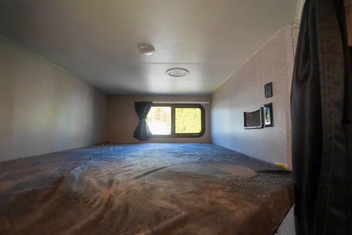 Cozy RV bunk bed interior with window, outlets, and comfy blanket, perfect for your next RV rental adventure.. Starcraft Super Lite 2021