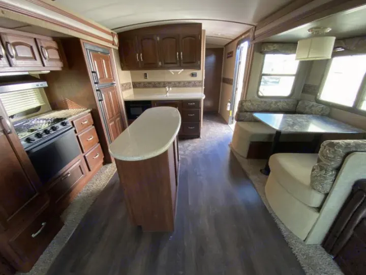 Step inside this spacious RV rental featuring a full kitchen, island, and comfortable dining/living area. Your home on wheels.. Keystone 316-UL 2014