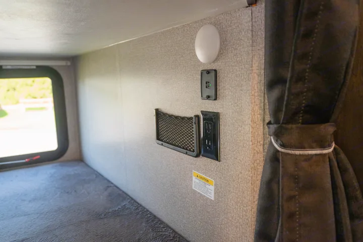 RV rental bunk with window, integrated light, USB/AC outlets, and net storage. Ideal for compact travel.. Starcraft Super Lite 2021