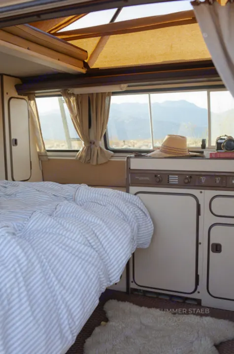 Your cozy home on wheels: this RV rental offers a comfortable bed, compact kitchen, and incredible mountain views.. Volkswagen Westfalia 1986