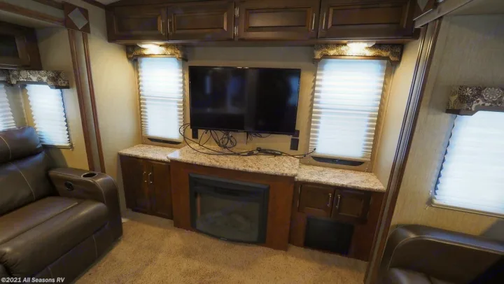 Experience comfort in this RV rental living area featuring a TV, electric fireplace, and recliners.. Keystone Outback 2016