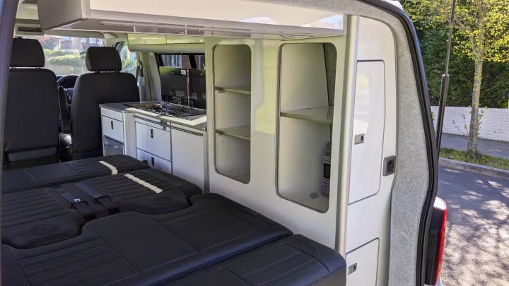 Spacious RV rental interior featuring a full kitchen, comfortable bed, and ample storage, perfect for mobile living.. vw T6 2016