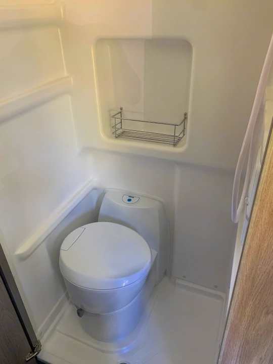 This RV rental features a compact wet bath with a toilet, shower hose, and handy storage rack for toiletries.. Winnebago Winnebago 2021