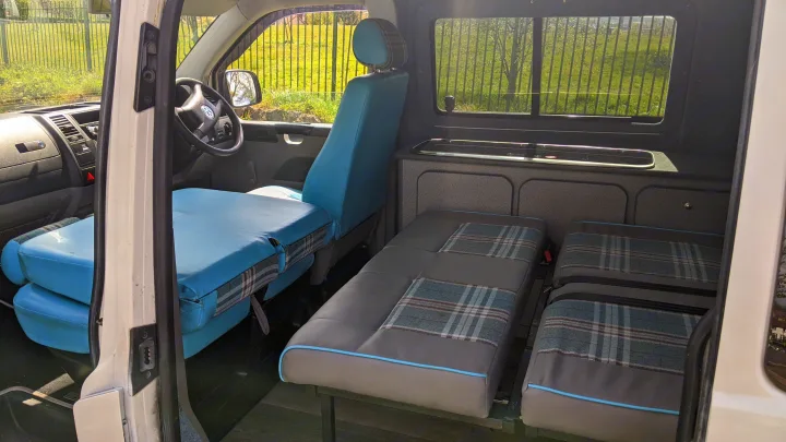 RV rental: Bright interior featuring a convertible bed, swiveling front seats, and a compact kitchenette.. vw T5 2004