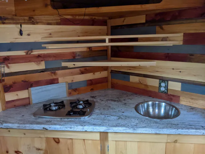 Nice little kitchen with two burners and small sink. Storage above and underneath for your food. . Stealth custom camper 2018