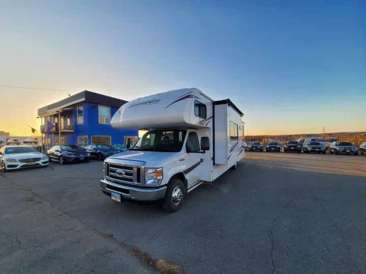 This white Sunseeker RV, likely for rv rental, is parked at a dealership on a sunny day.. Forest River Sunseeker 2018