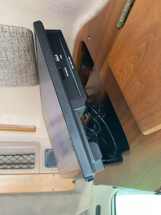 Side view of an RV rental entertainment system: a mounted media player with USB, SD, and disc slots for in-vehicle viewing.. Coachmen Van Conversion 2001