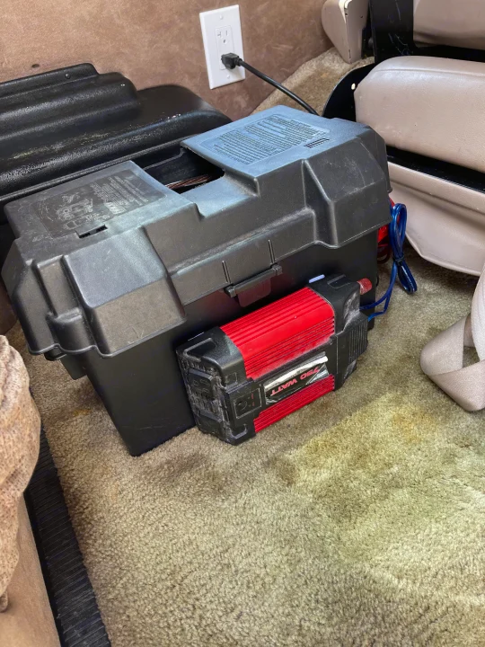 **RV rental** power setup: 750-watt inverter & battery box on the floor, charging via wall outlet in the carpeted interior.. Coachmen Van Conversion 2001