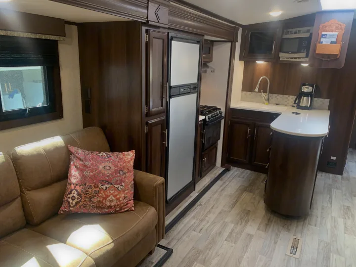 RV rental interior: fully-equipped kitchen (fridge, stove, microwave, coffee maker, sink) & comfy sofa.. Jayco White Hawk 2018