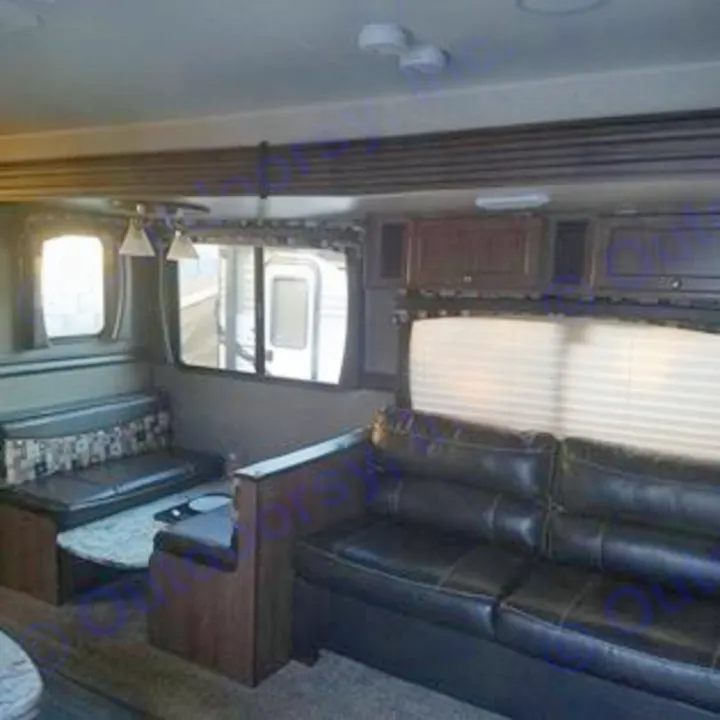 This RV rental's living area features a dark sofa, U-shaped dinette, and modern decor. Perfect for your travels.. Heartland Pioneer 2016