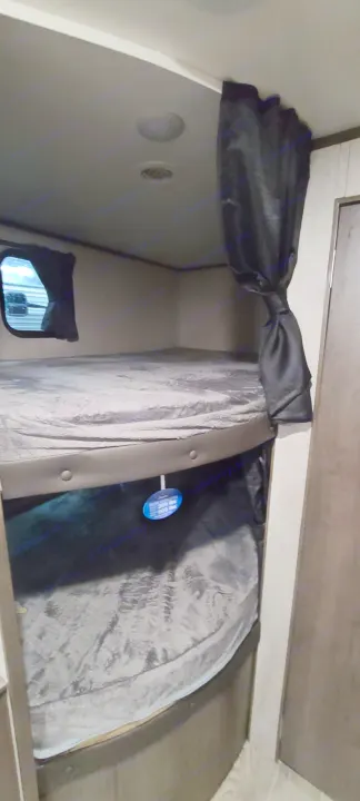 Experience comfort in an RV rental! Compact bunk beds with window and privacy curtain, ideal for travel trailer adventures.. Jayco Jay Flight 2021