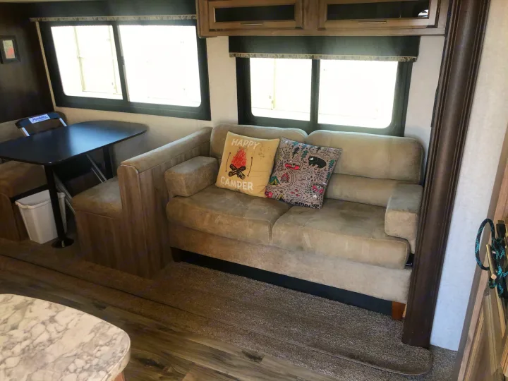 Cozy RV rental living area featuring a dining booth, sofa, and bright windows, ready for adventure.. Jayco Jay Feather 2018