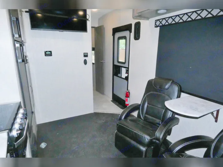 Spacious RV rental interior featuring comfortable recliners, a TV, and kitchen amenities. Ideal for travel comfort.. Forest River Work And Play 2021