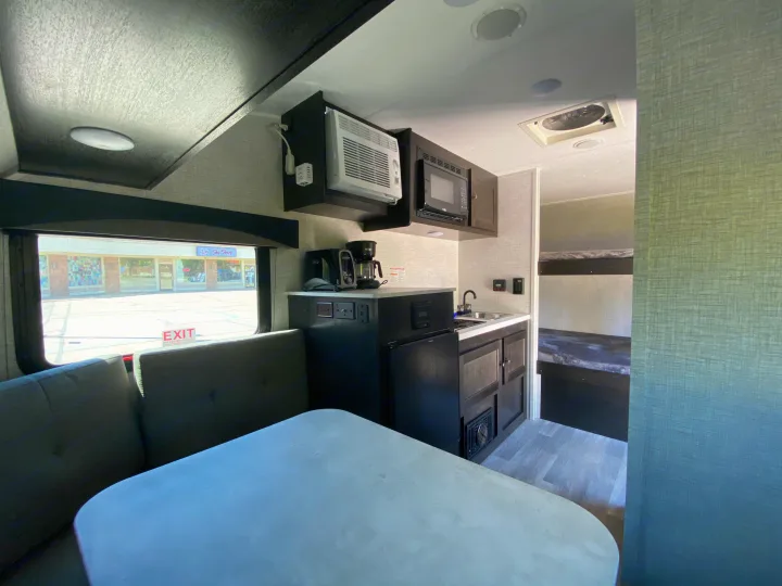 This rv rental features a well-equipped kitchen, dining area, and bunk beds, offering a cozy and functional interior.. Bushwacker 17BH 2021