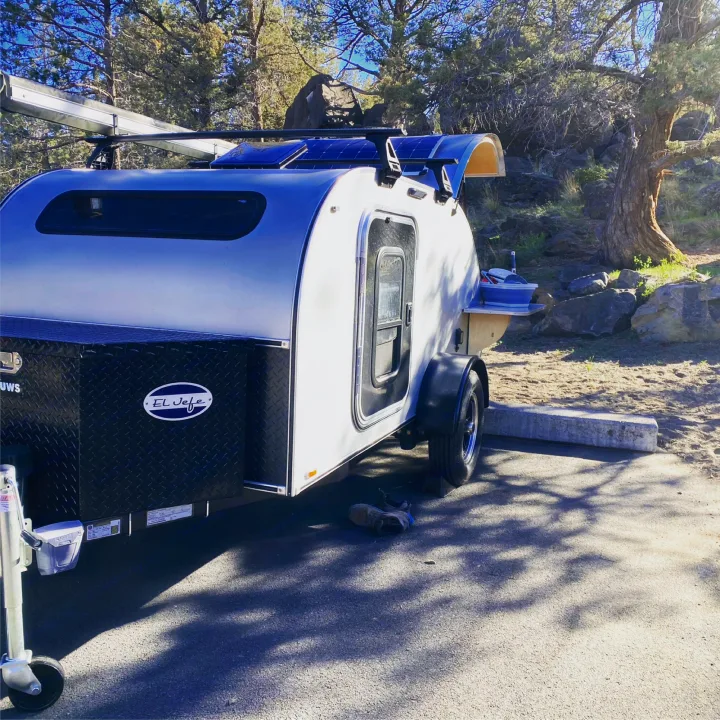 Teardrop RV rental parked in a scenic spot, equipped with solar panels for off-grid adventures and camping.. Aero Teardrops Teardrop Camper 2022