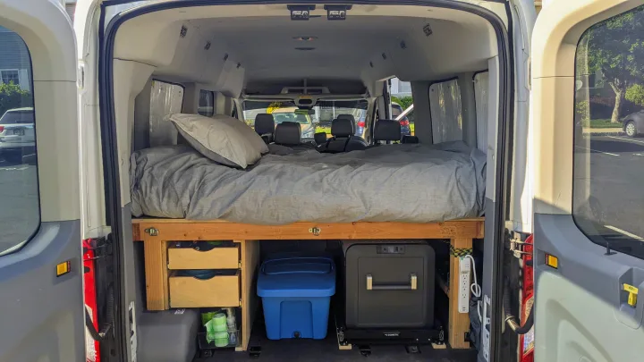 Converted van interior: raised bed, storage, Dometic fridge, perfect for an RV rental or mobile living.. Ford Transit 2015