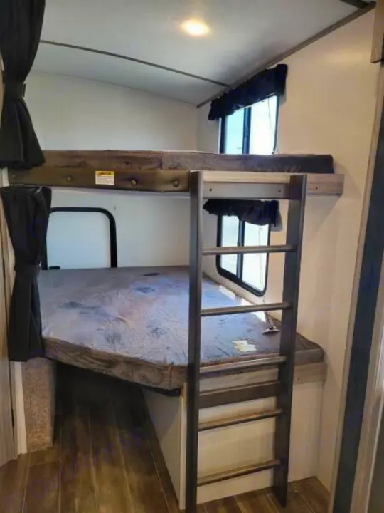RV rental: Bunk beds with a ladder dominate this interior view, offering a functional and cozy sleeping area.. Keystone Passport 2021