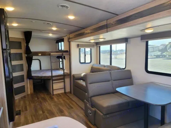 Spacious RV rental interior featuring bunk beds, a dinette, and sofa seating, perfect for family travel.. Keystone Passport 2021