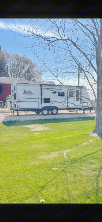White Jay Flight RV rental parked on gravel next to a green lawn under a sunny sky.. Jayco Jay Flight 2018