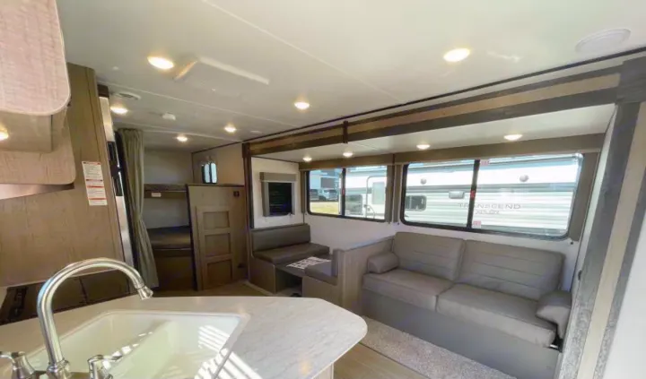 This rv rental shows a full interior with kitchen sink, living area (sofa & dinette), and private bunk beds.. Other Hideout 2021