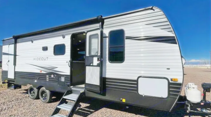 RV rental: White & black Hideout travel trailer with open door, steps, & awning, ready for your next trip.. Other Hideout 2021