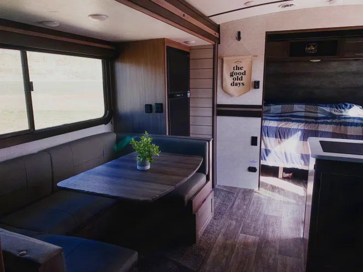 Cozy RV rental features a modern dinette, kitchenette, and comfortable bedroom, ready for your travel adventures.. Crossroads RV Sunset Trail Super Lite 2021