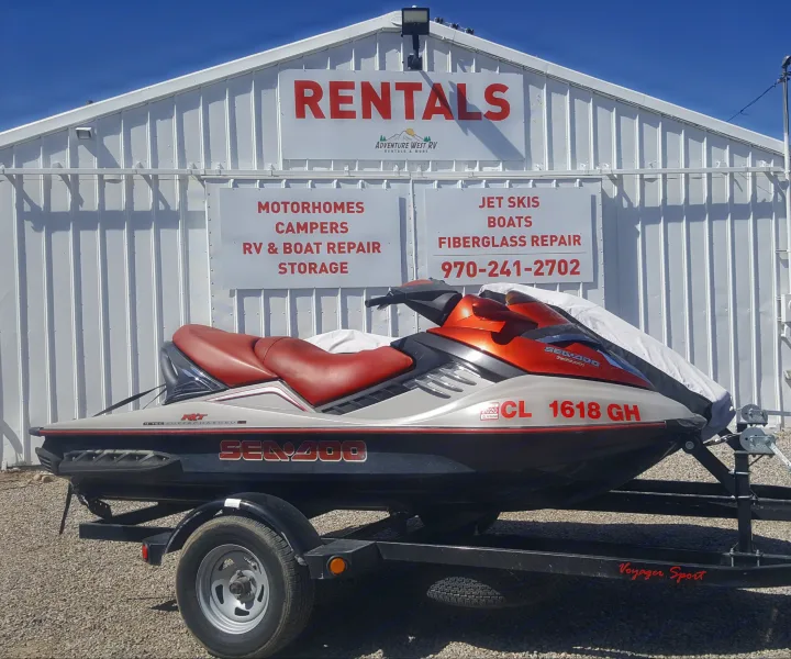 Bright orange jet ski on trailer at Adventure West RV Rentals & More, offering RV rental, boat & jet ski services.. Sea Doo RXT 2012