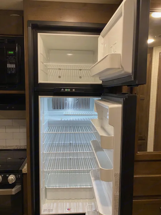 Empty RV rental refrigerator with its freezer compartment open.. Jayco REDHAWK 2020