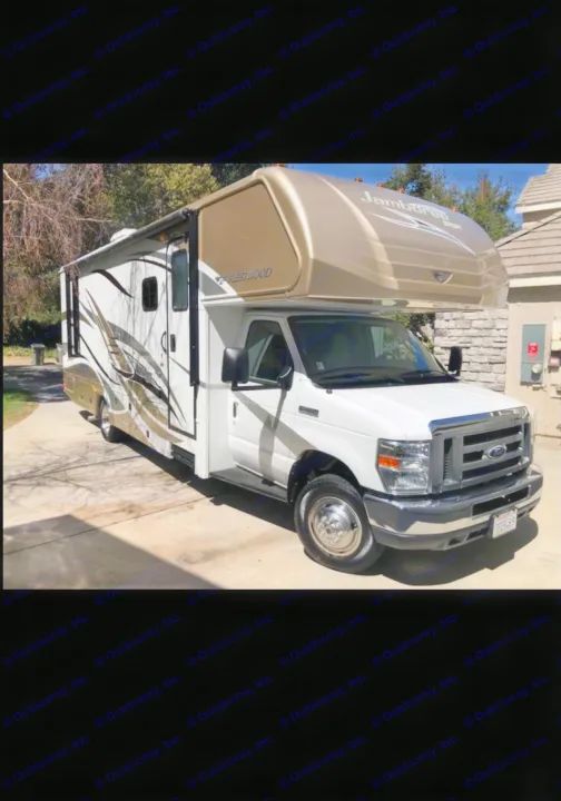 This white and tan Class C motorhome, ideal for rv rental, is seen parked on a sunny driveway.. Fleetwood Jamboree Sport 2014