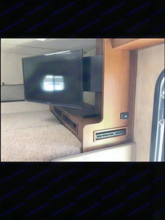 RV rental interior: A cozy bed and swivel TV, with a nearby control panel & storage, offer comfort for your journey.. Fleetwood Jamboree Sport 2014