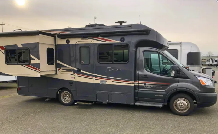 Modern gray and cream Class C Fuse RV rental on a Ford Transit chassis, featuring an extended slide-out, parked outside.. Winnebago Winnebago 2018