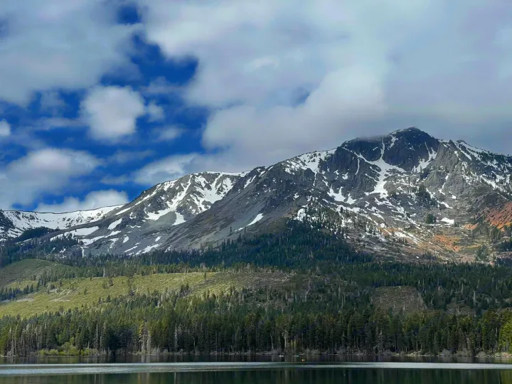 Majestic snow-capped mountains, lush forests, and a tranquil lake under cloudy skies. Perfect scenery for an RV rental adventure.. Jayco Jay Flight 2021