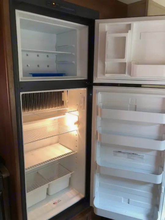 Inside a large, multi-door RV refrigerator/freezer, empty and clean for your rv rental. Brightly lit storage ready.. Coachmen 310 BHDS 2015