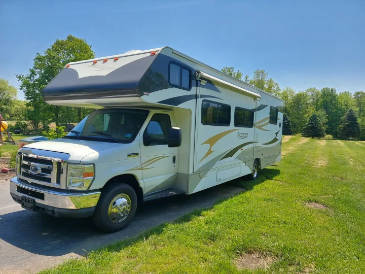 Beautiful white & gray Access Class C RV rental, ready for adventure on a bright, clear day.. Winnebago Access 2011