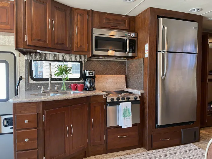 Spacious, well-equipped RV kitchen: wood cabinets, stainless appliances, and counter space for your rv rental trip.. Coachmen Mirada 35BH 2016