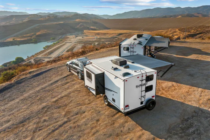 Two Sunset Trail RV rental trailers & an SUV parked overlooking a reservoir, dam, and mountains. Perfect for camping.. Crossroads Sunset Trail Super Lite 2021