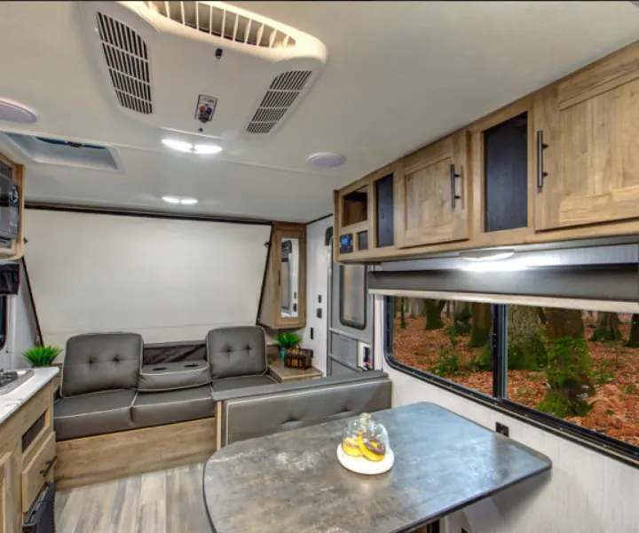 Spacious RV rental interior featuring a comfortable dinette, sofa, and kitchen area. Ideal for your next road trip.. Pioneer BH170 2021