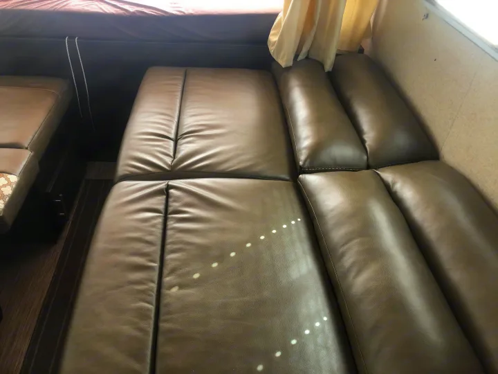 Comfortable grey faux leather seating in an RV rental, showing a cozy interior with ample natural light.. Dutchmen Kodiak 2019