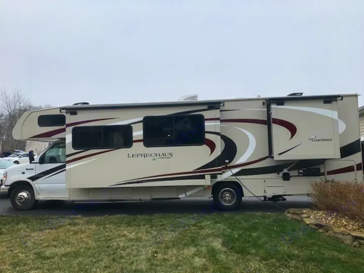 Side view of a beige and burgundy Coachmen Leprechaun RV, ready for your next rv rental adventure.. Coachmen Leprechaun 2018