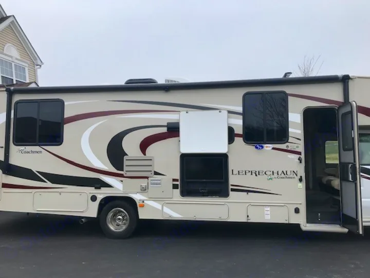 Beige Class C Coachmen Leprechaun RV available for rv rental, featuring an outdoor TV & open entry door for easy access.. Coachmen Leprechaun 2018